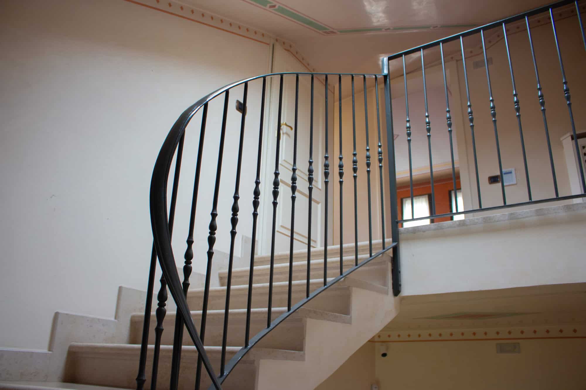 Elegant staircase with black metal railing in a contemporary home interior.