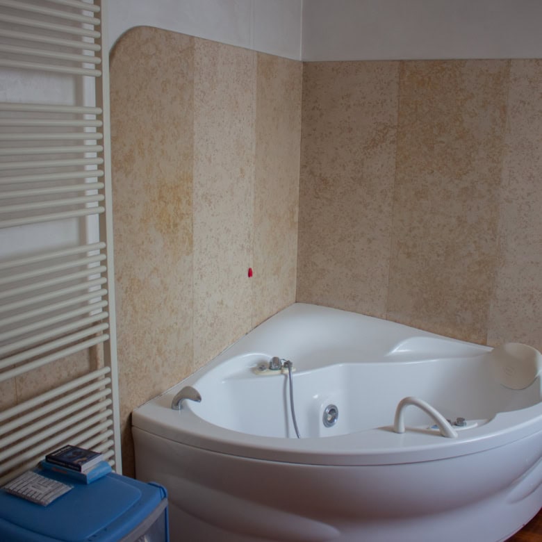 Luxury corner whirlpool bathtub for home spa and relaxation.