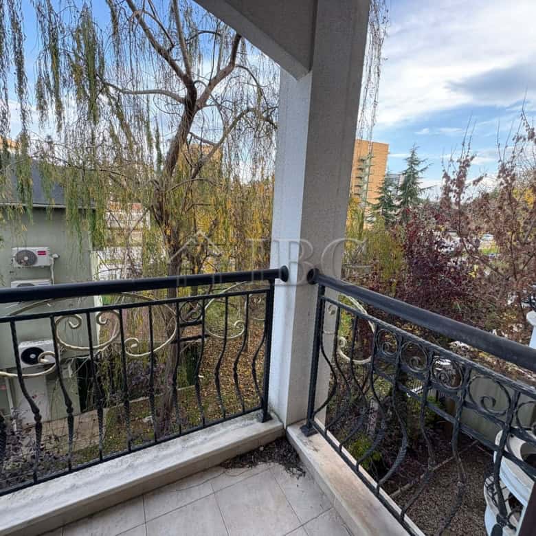 Balcony with pool view overlooking trees and neighboring buildings in Harmony Palace, Sunny Beach.