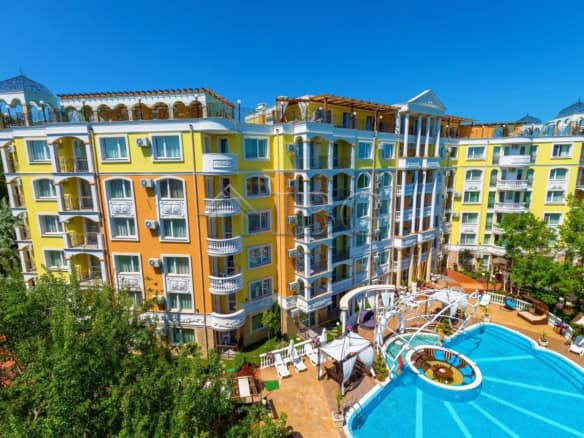 Bright yellow and white one-bedroom apartment in Sunny Beach with balcony views.