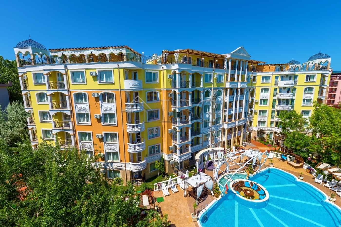 Bright yellow and white one-bedroom apartment in Sunny Beach with balcony views.