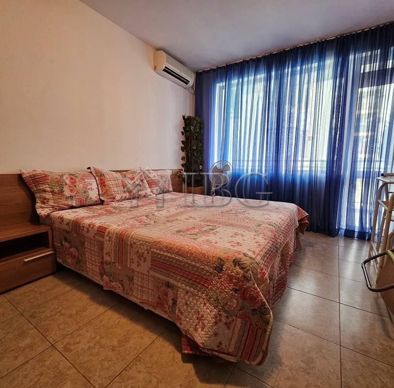 Bright bedroom with large window and blue curtains in Sveti Vlas apartment.