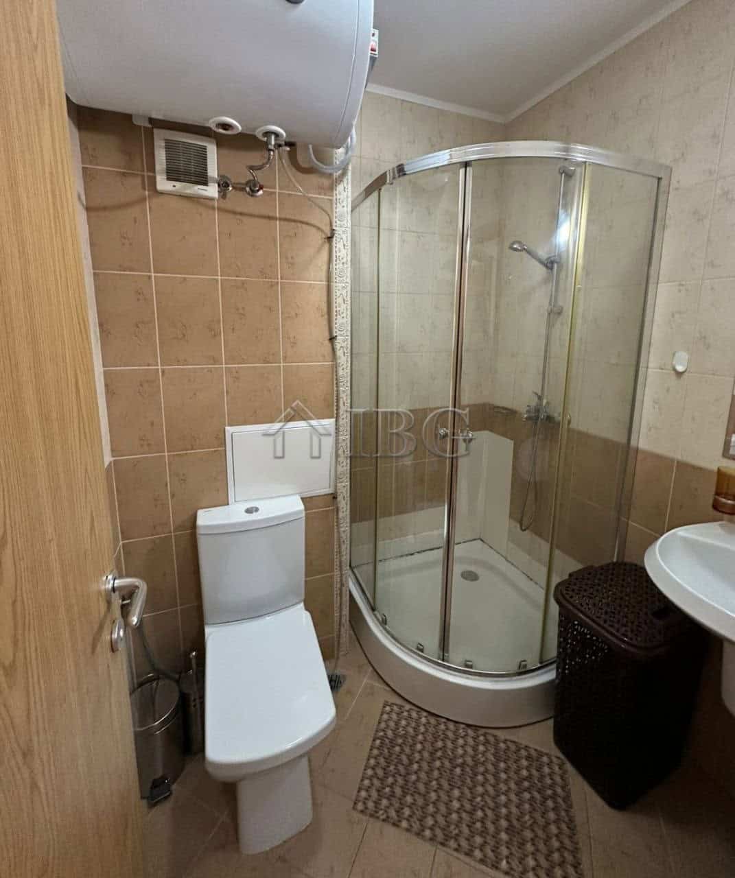 Small bathroom with shower, toilet, and sink in Royal Sun apartment, Sunny Beach.