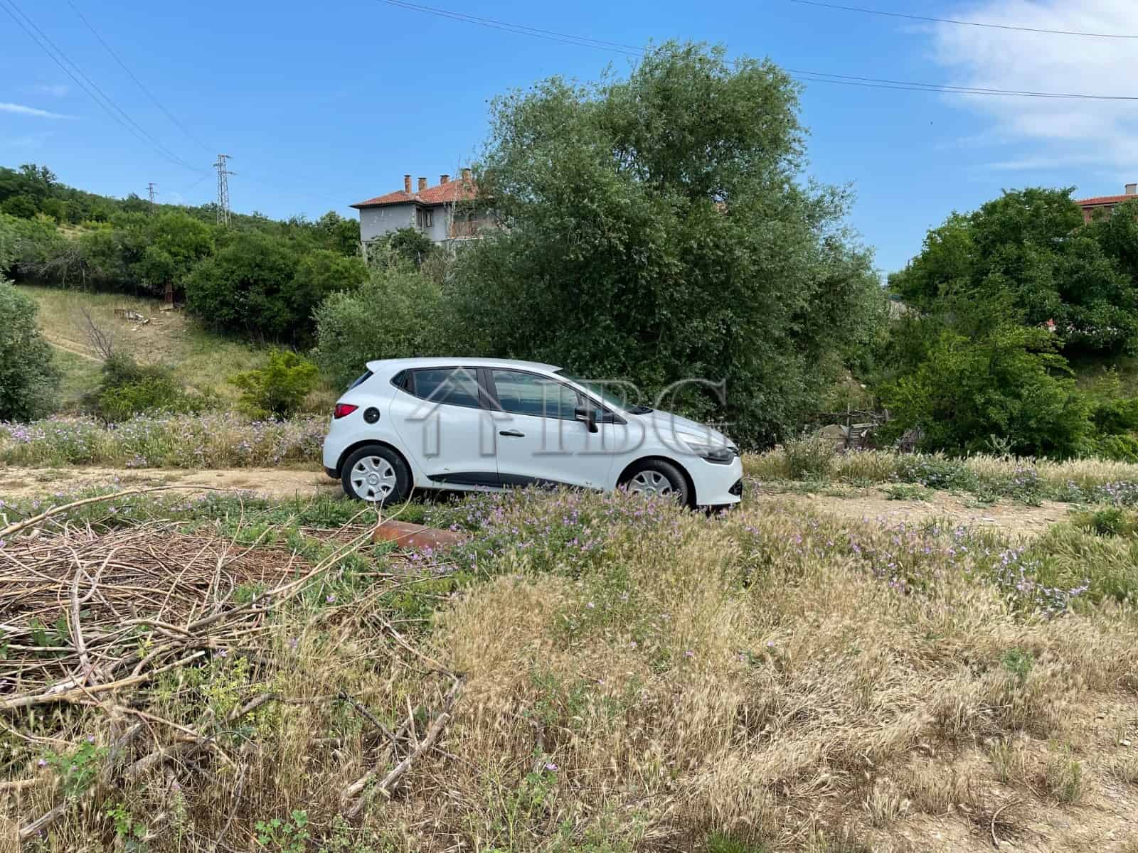 Plot of land with a car parked, surrounded by greenery in Kosharitsa.