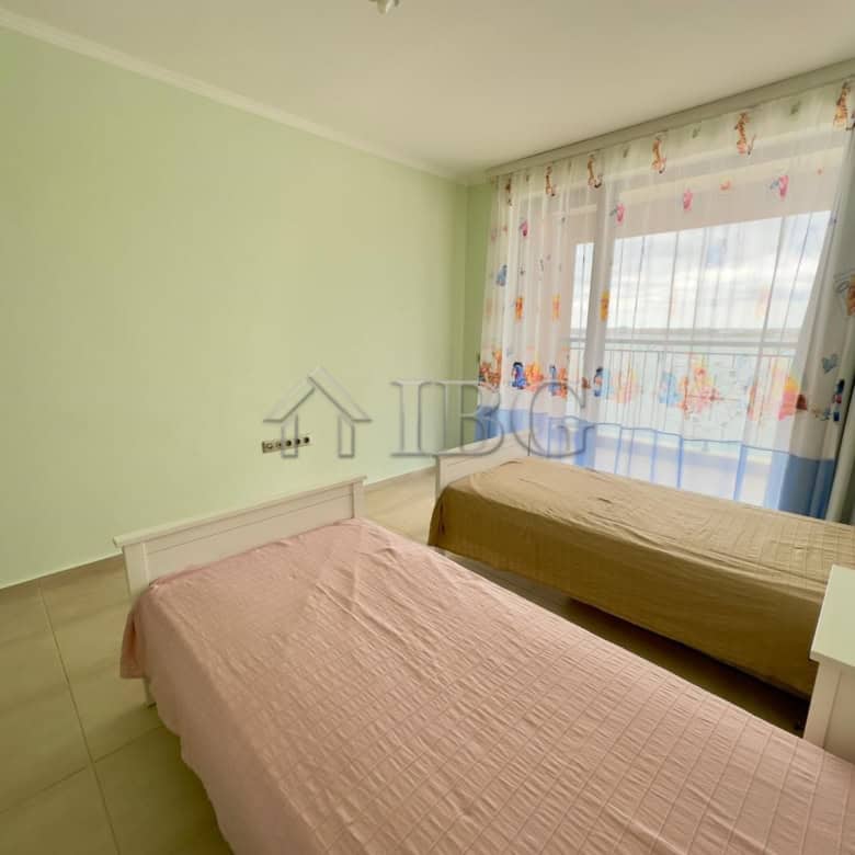 Bright room featuring pastel walls, colorful curtains, and minimal decor.