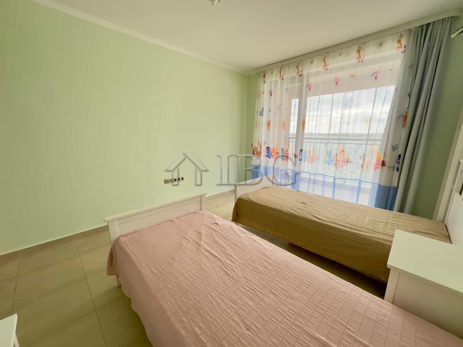 Bright room featuring pastel walls, colorful curtains, and minimal decor.