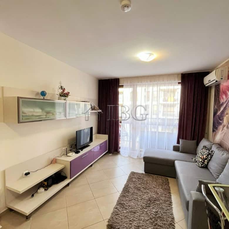 Furnished 1-bedroom apartment living room with sofa, TV, and modern decor at Cascadas Family Resort.