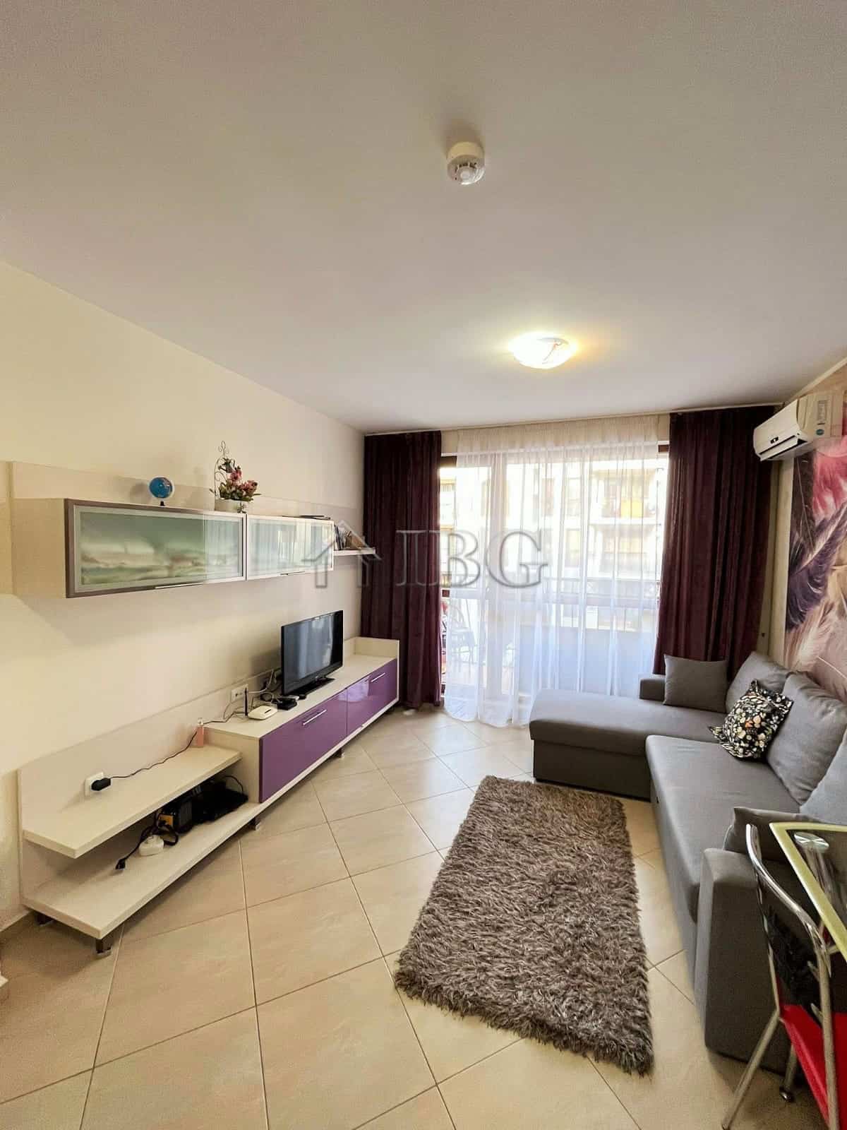 Furnished 1-bedroom apartment living room with sofa, TV, and modern decor at Cascadas Family Resort.