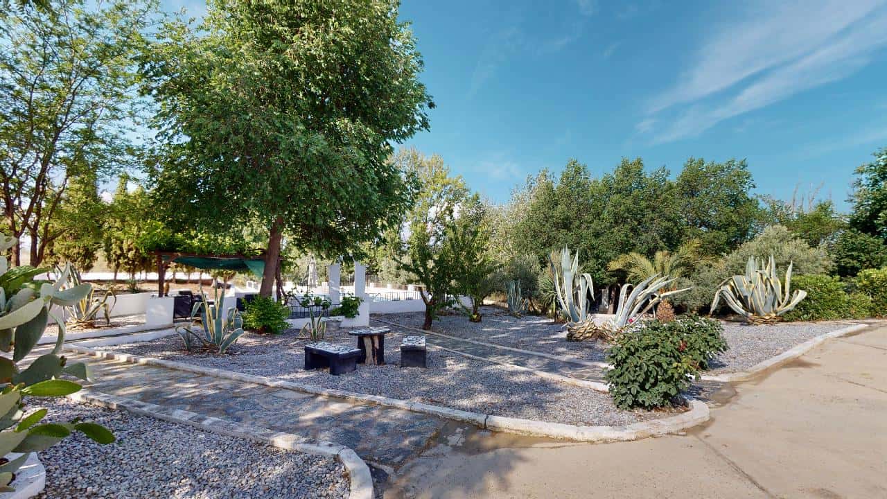 Boutique hotel for sale in Caniles, Granada, Spain, featuring charming outdoor gardens and lush gree.