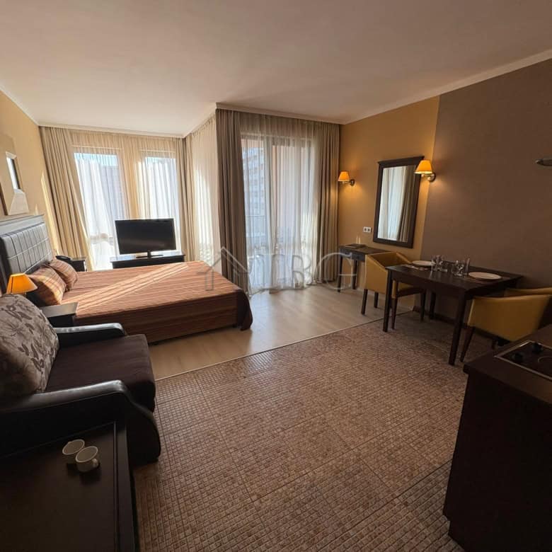 Modern studio apartment with pool view in Sunny Beach, featuring a comfortable sleeping area, seatin.