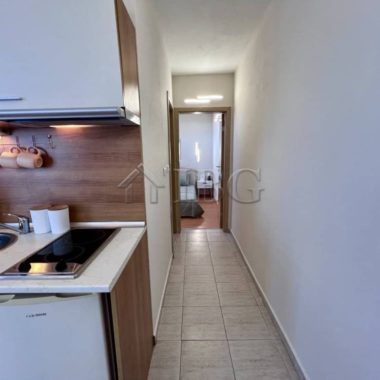 Apartment with pool view in Sveti Vlas, Bulgaria, featuring a compact kitchen and hallway.
