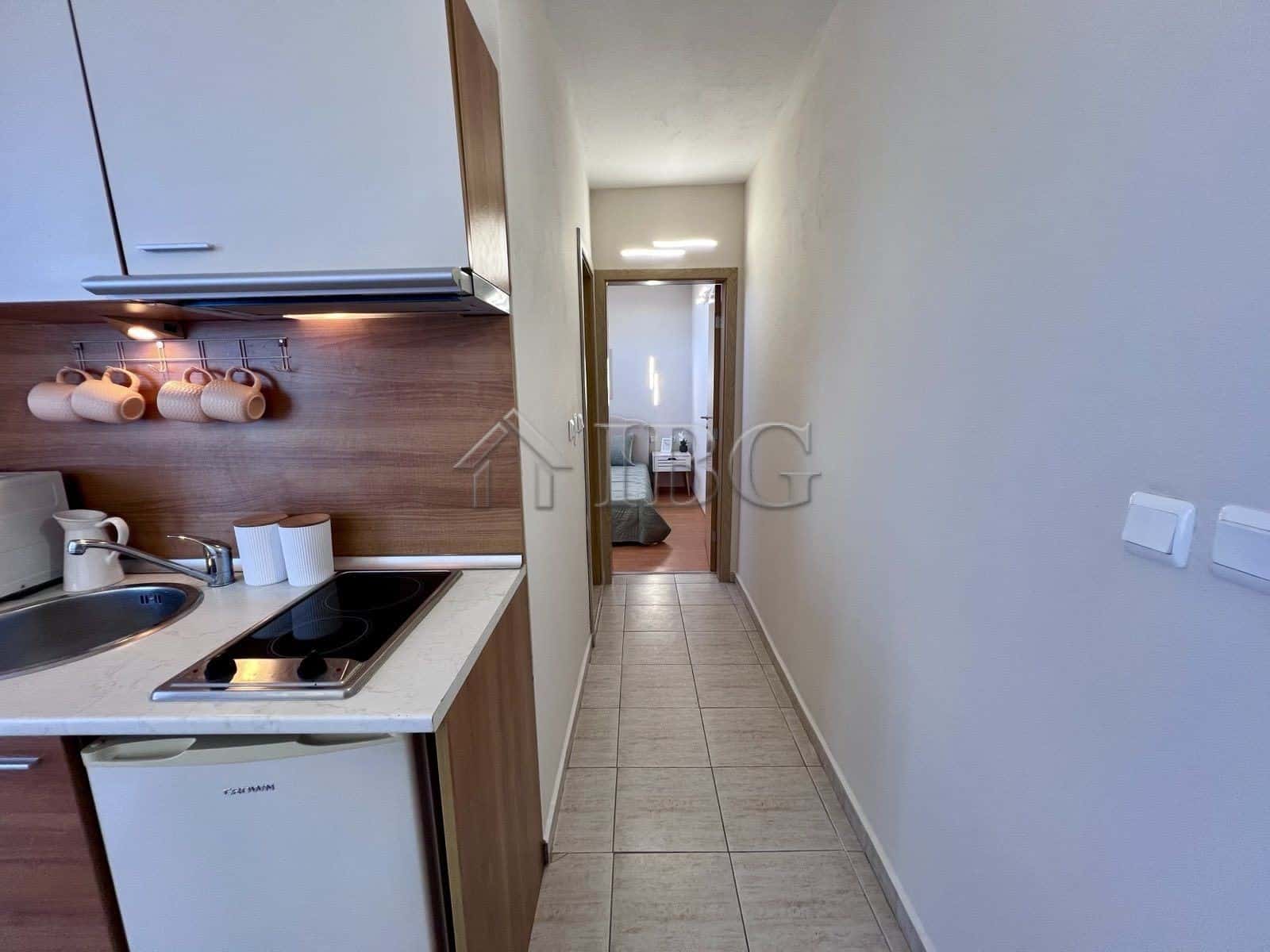 Apartment with pool view in Sveti Vlas, Bulgaria, featuring a compact kitchen and hallway.