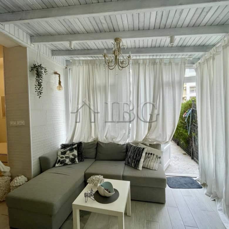 Sun Gate apartment living room with bright, airy space and white curtains.