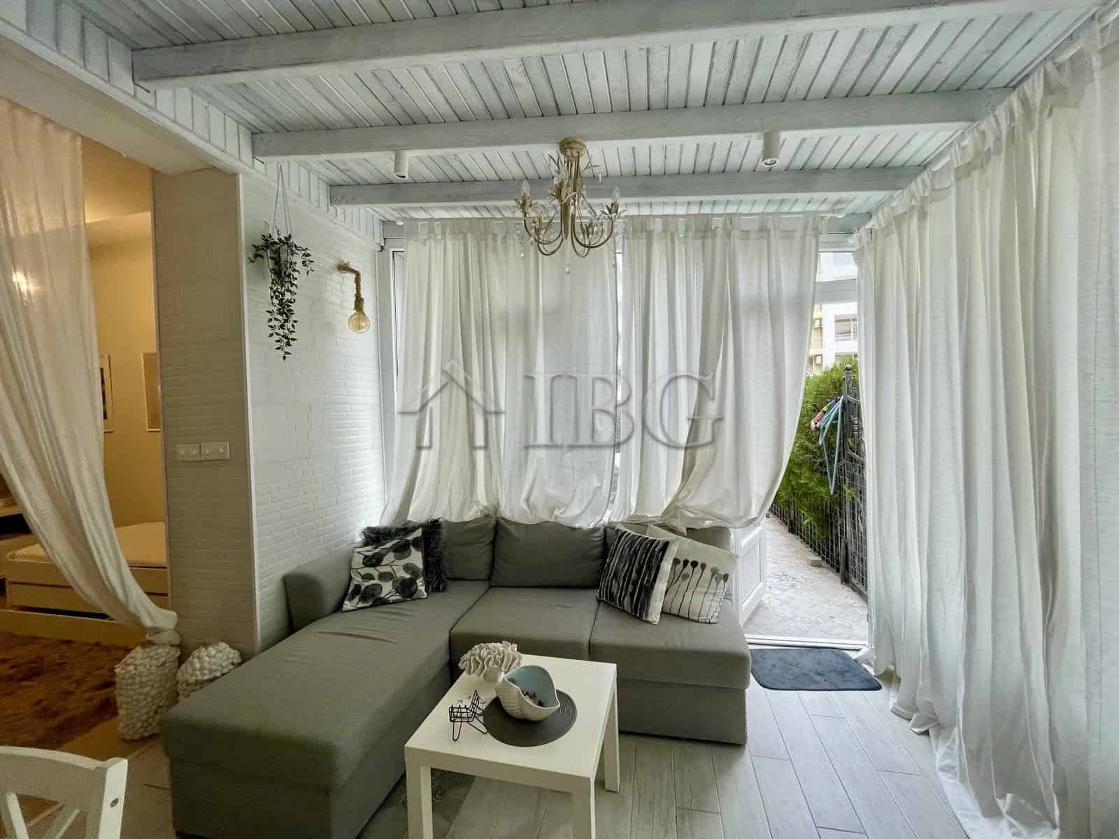 Sun Gate apartment living room with bright, airy space and white curtains.