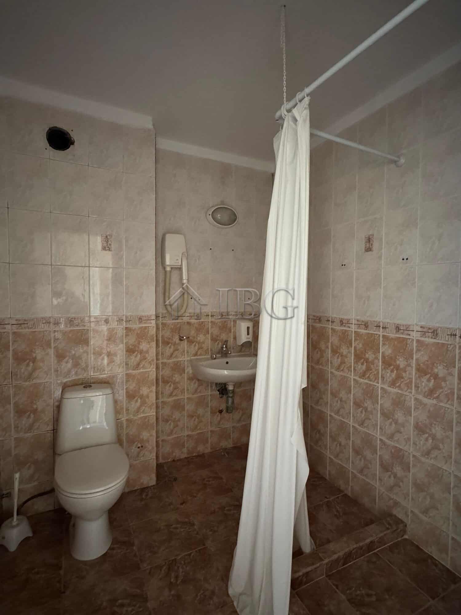 Hotel bathroom with toilet and shower area in Sunny Beach.