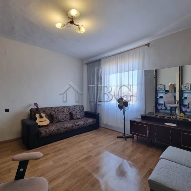 Vinarsko Village house interior with sofa, guitar, and dressing table, showcasing a cozy living spac.