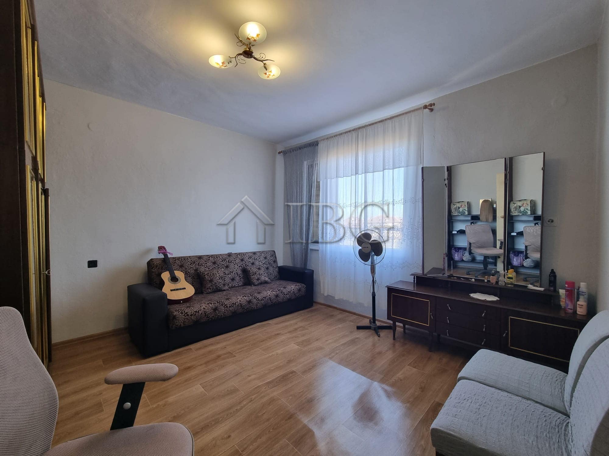 Vinarsko Village house interior with sofa, guitar, and dressing table, showcasing a cozy living spac.