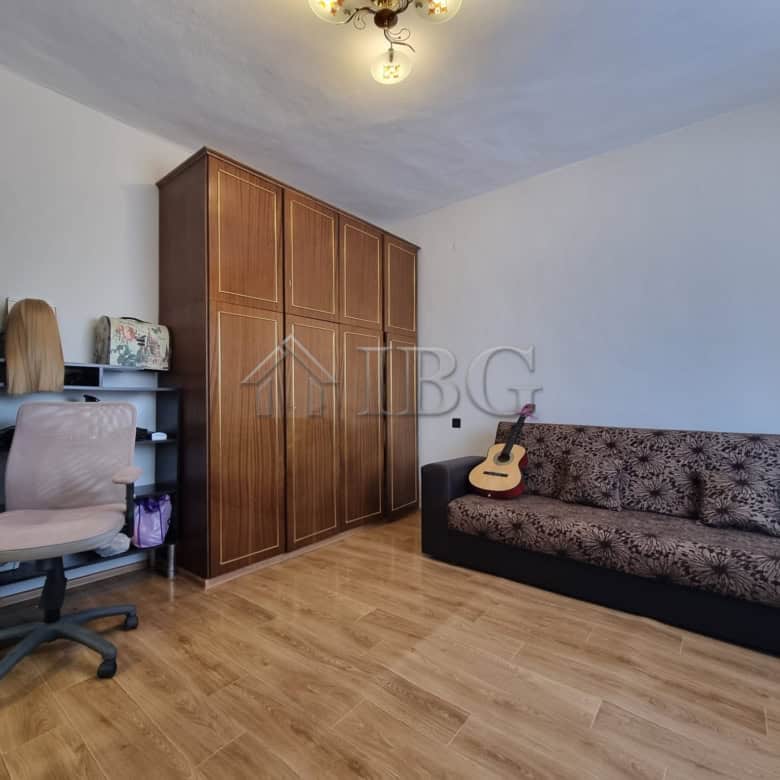 Interior of a living room with a sofa, guitar, and workspace in Vinarsko Village, Burgas Region.