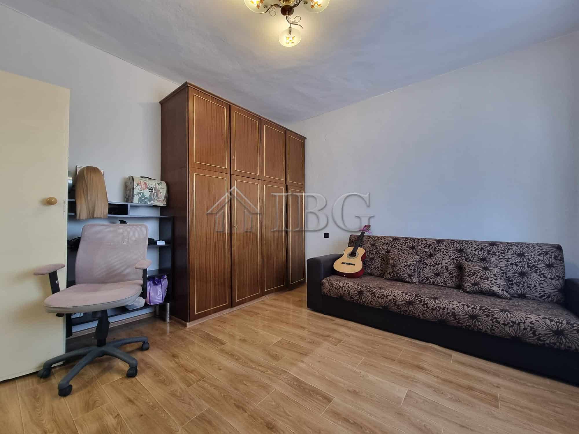 Interior of a living room with a sofa, guitar, and workspace in Vinarsko Village, Burgas Region.