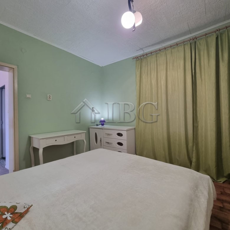 Cozy bedroom in Vinarsko Village with green walls and large curtains, ideal for a peaceful countrysi.