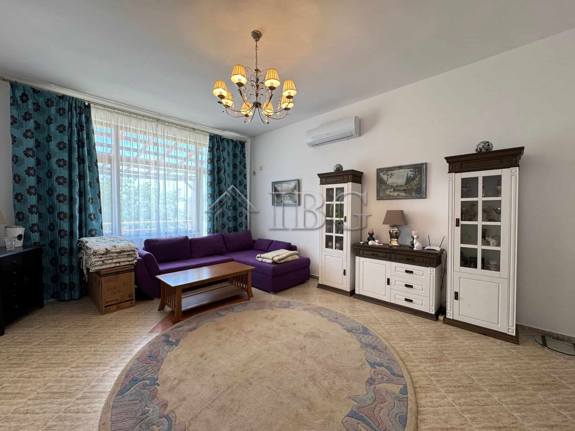 Bright living room with elegant furniture and large window in Kosharitsa home.