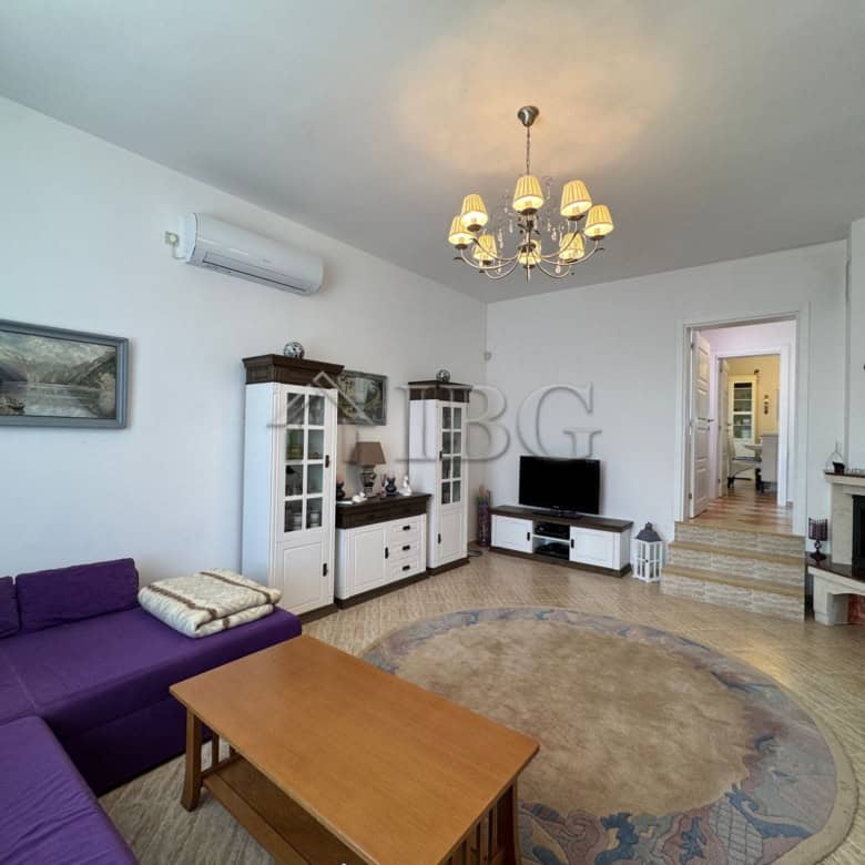 Bright living room with modern furniture and cozy decor in a two-storey house near the sea.