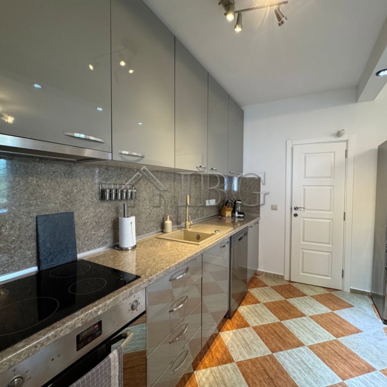 Modern kitchen with sleek cabinets and appliances in a two-storey home near the sea.