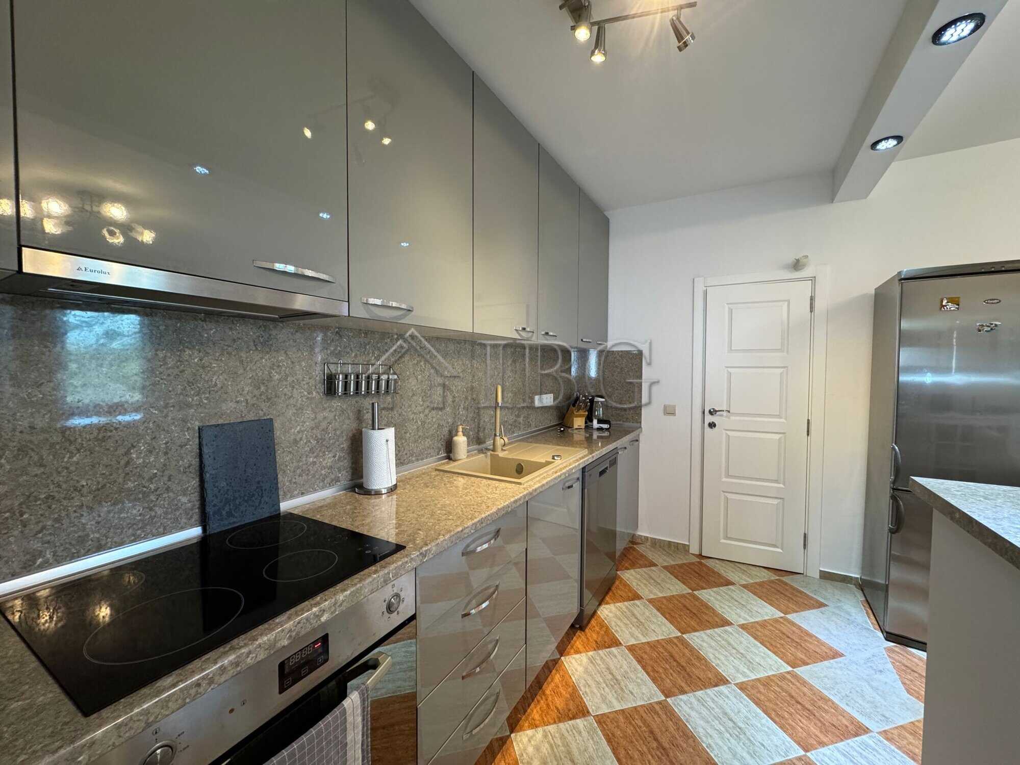 Modern kitchen with sleek cabinets and appliances in a two-storey home near the sea.