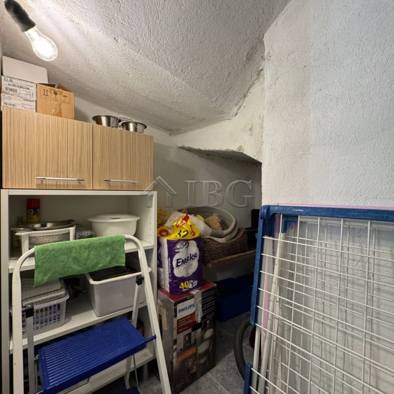 Compact storage room with shelves and household items in a two-storey house.