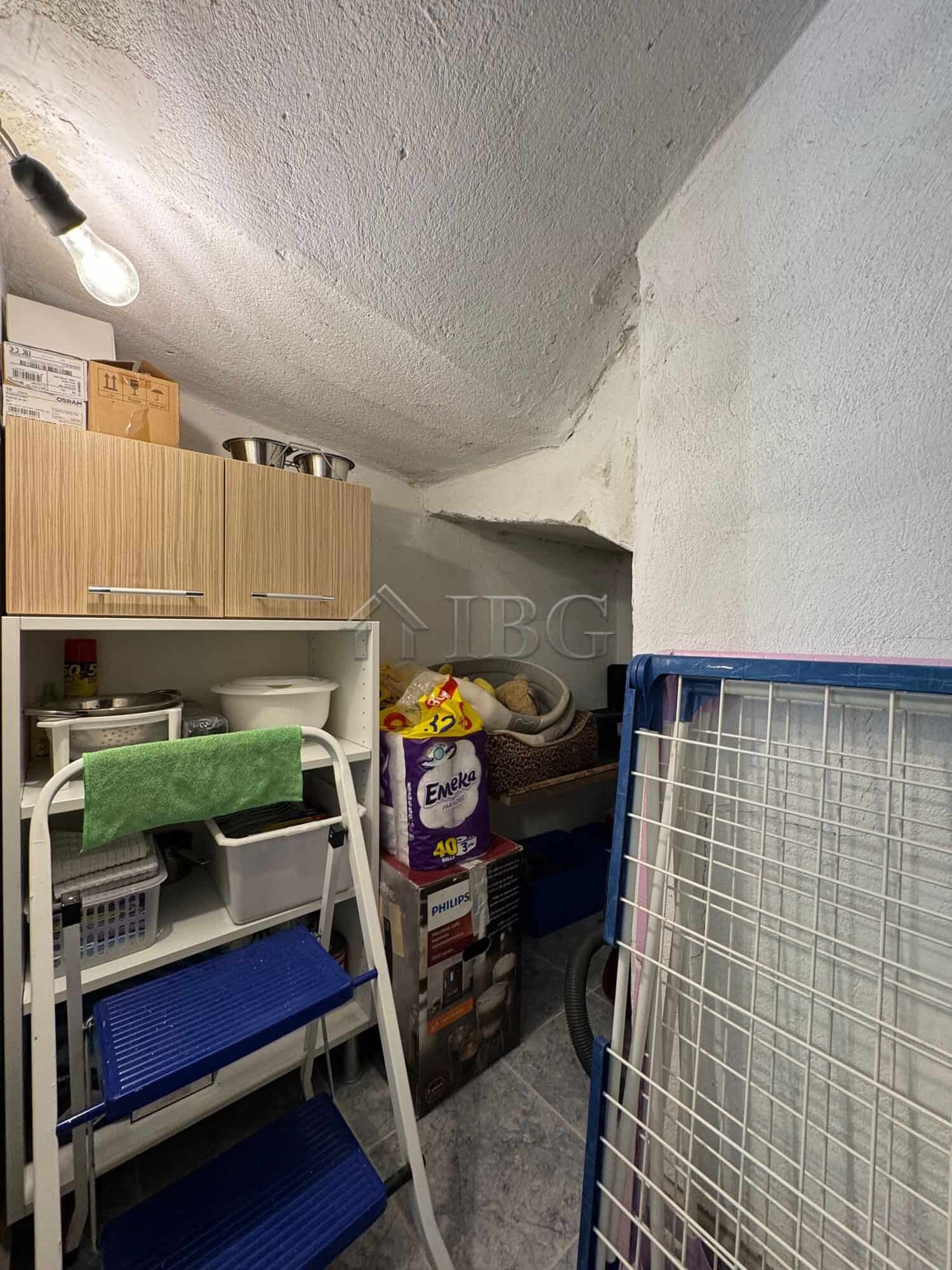 Compact storage room with shelves and household items in a two-storey house.