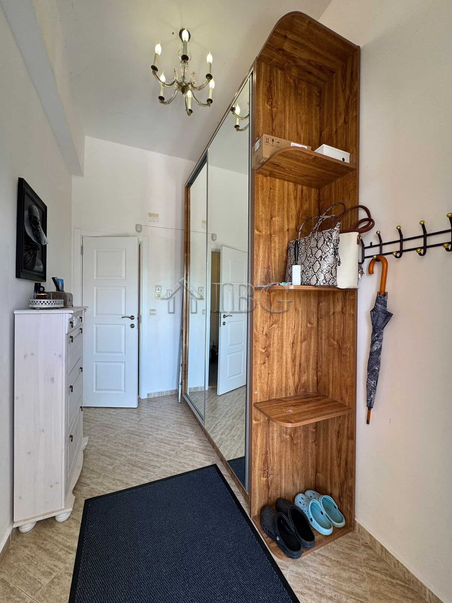 Modern hallway with wooden storage unit and mirror closet.