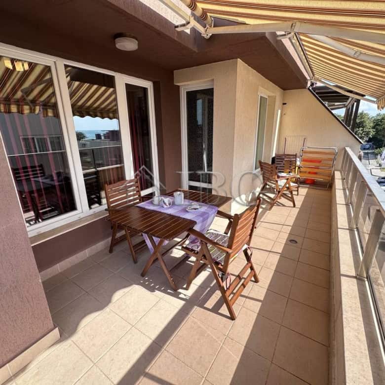 Balcony of a 1-bedroom apartment in Ravda with outdoor dining area and partial sea views.