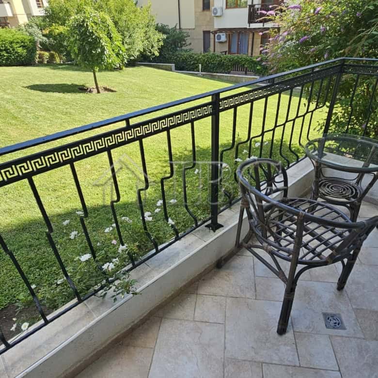 Balcony with outdoor seating overlooking a lush park in Sveti Vlas.