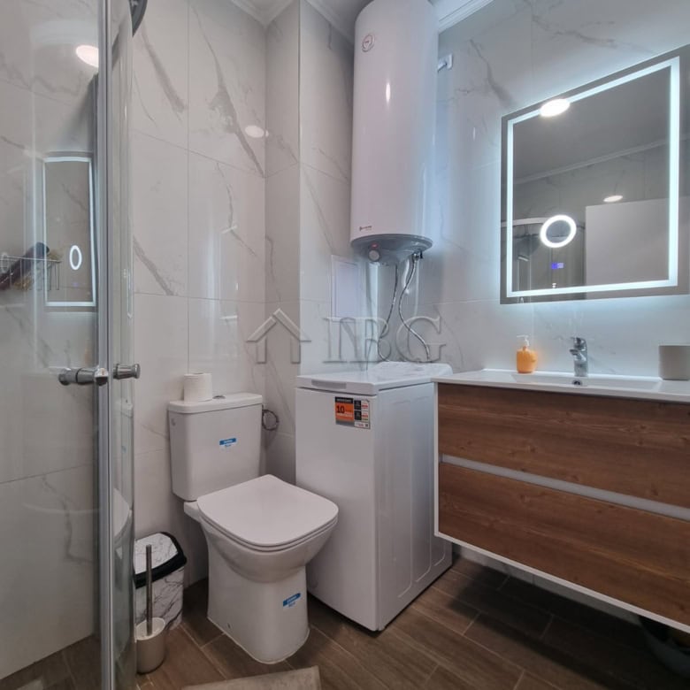 Bright bathroom with shower, toilet, and water heater in Domenico Complex, Sunny Beach.