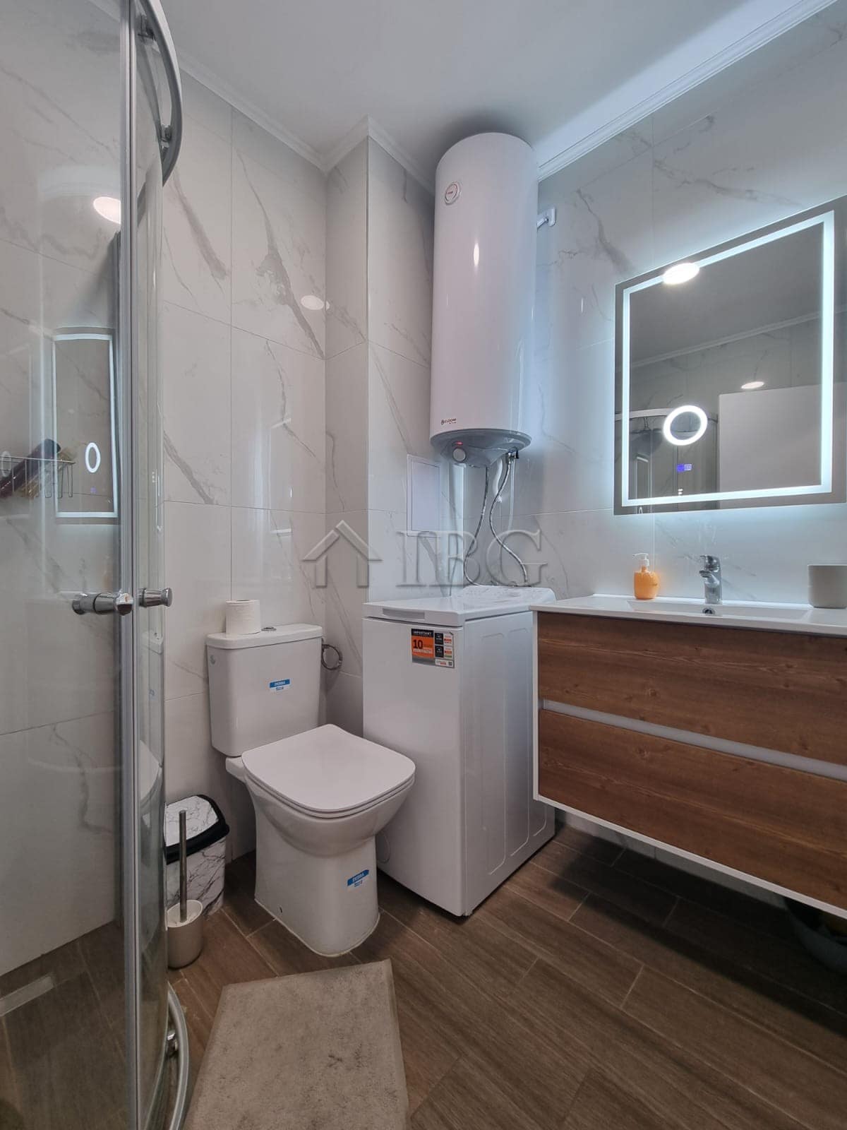 Bright bathroom with shower, toilet, and water heater in Domenico Complex, Sunny Beach.