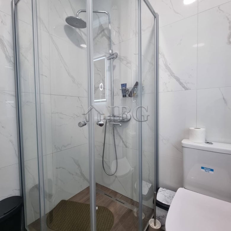 Shower cabin with glass doors in a stylish Sunny Beach apartment bathroom.