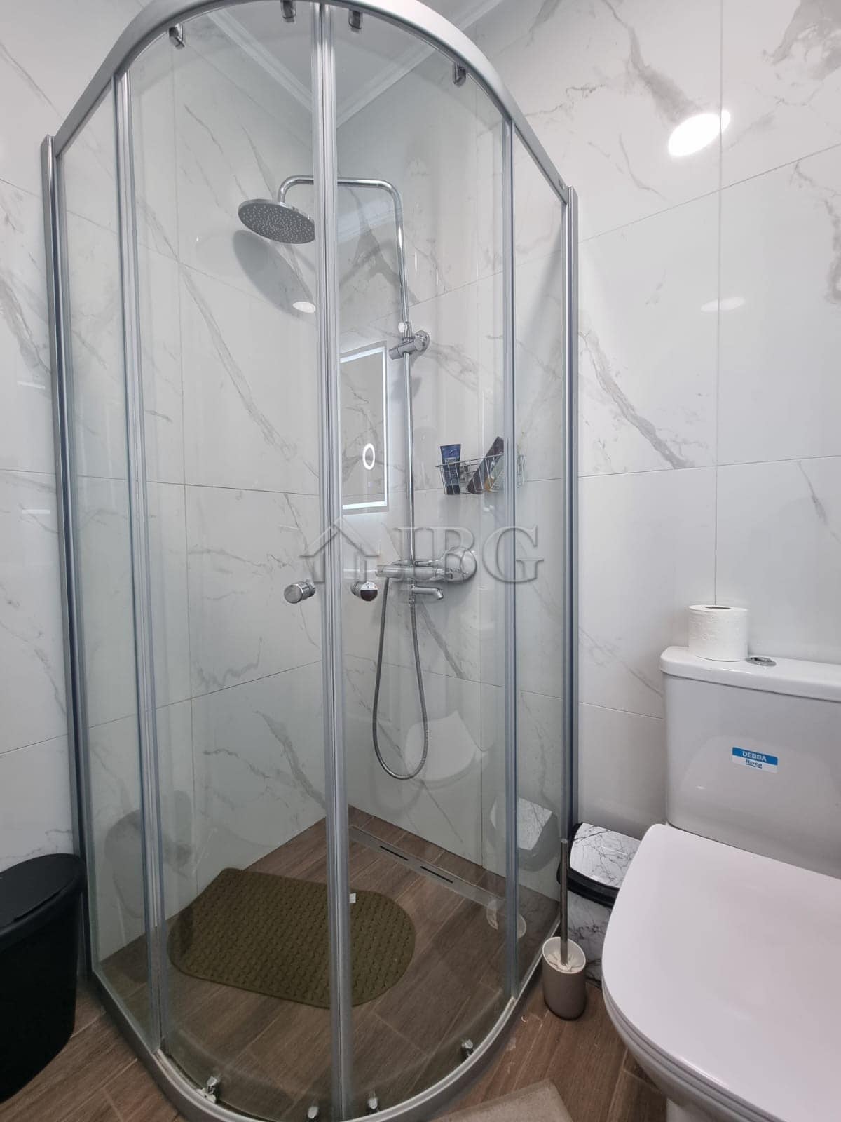 Shower cabin with glass doors in a stylish Sunny Beach apartment bathroom.