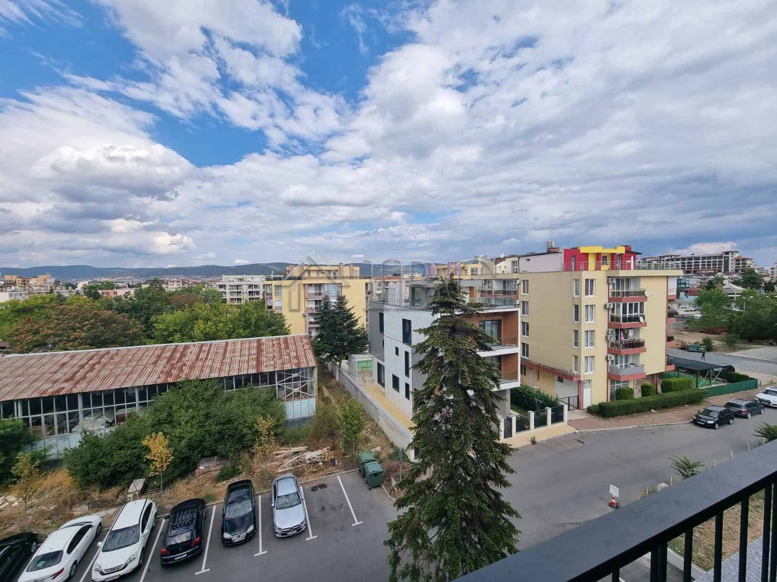 Apartment building in Sunny Beach with colorful exterior and surrounding greenery.