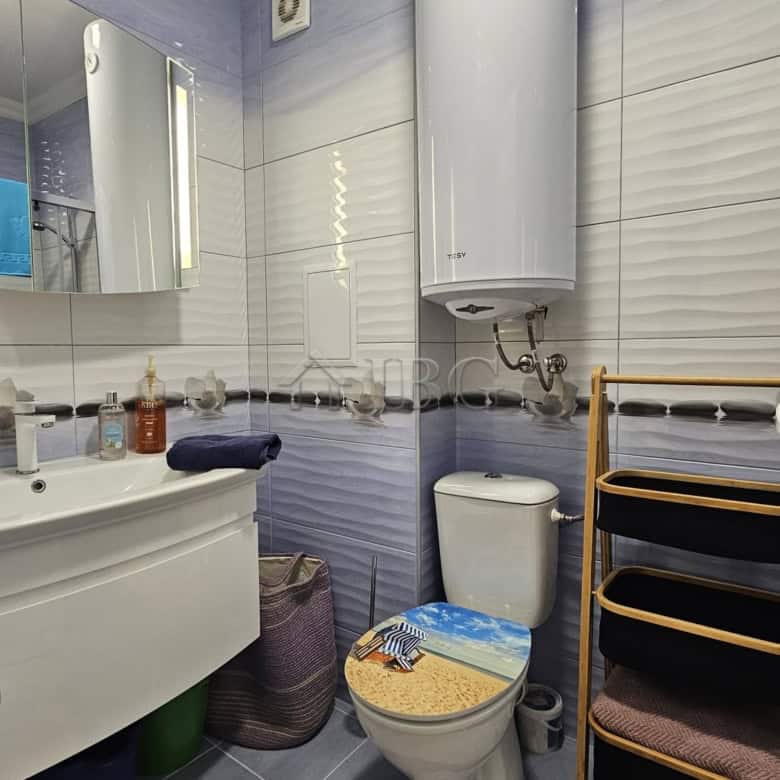 Bright bathroom with modern fixtures in Magnolia 6, Sunny Beach. Features a water heater, mirror, an.