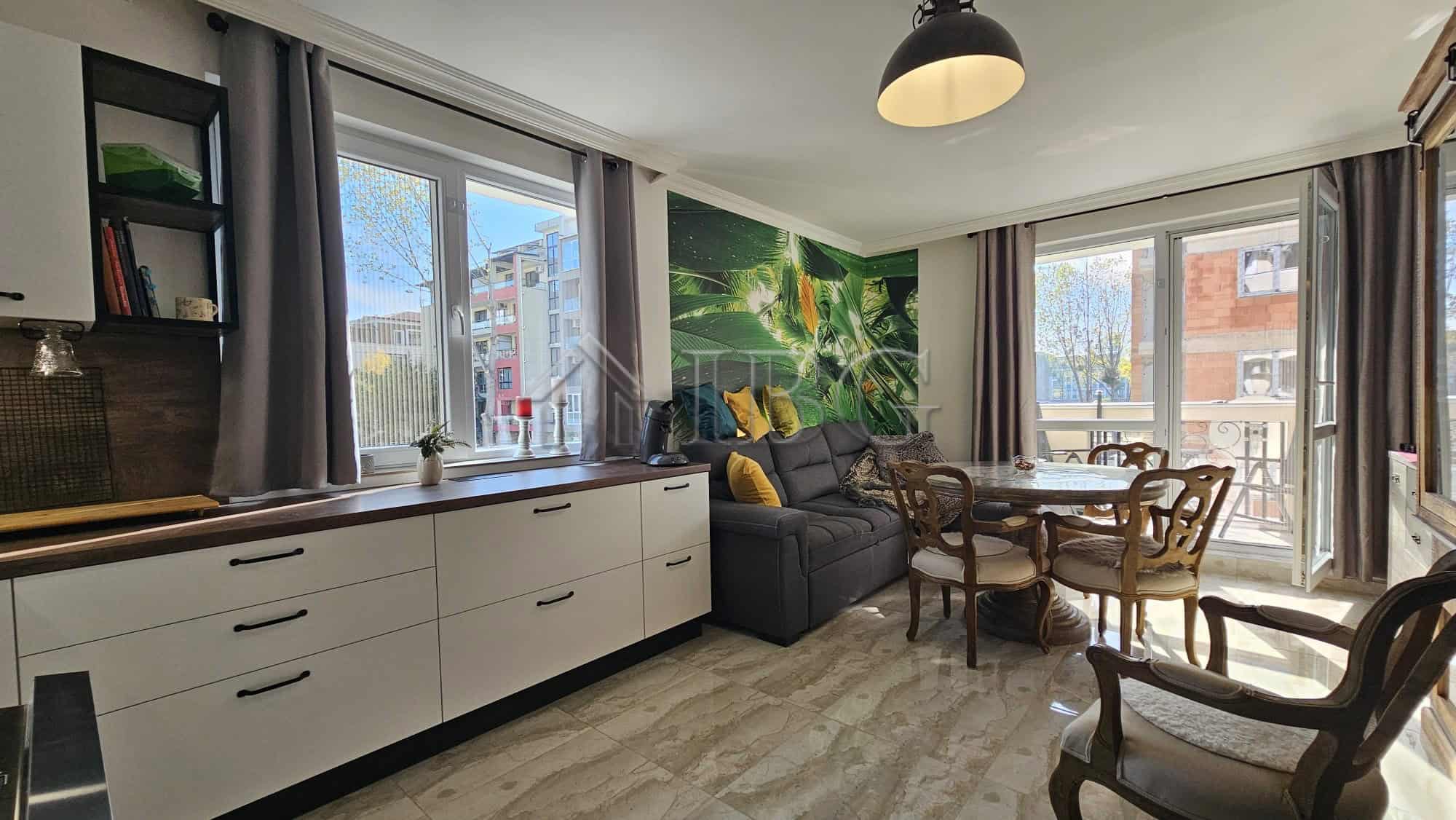 Bright living room with large windows and balcony views in Sunny Beach. Modern decor and comfortable.