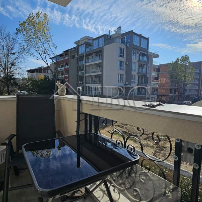 Balcony view of a spacious apartment in Magnolia 6, Sunny Beach, with outdoor seating and cityscape.