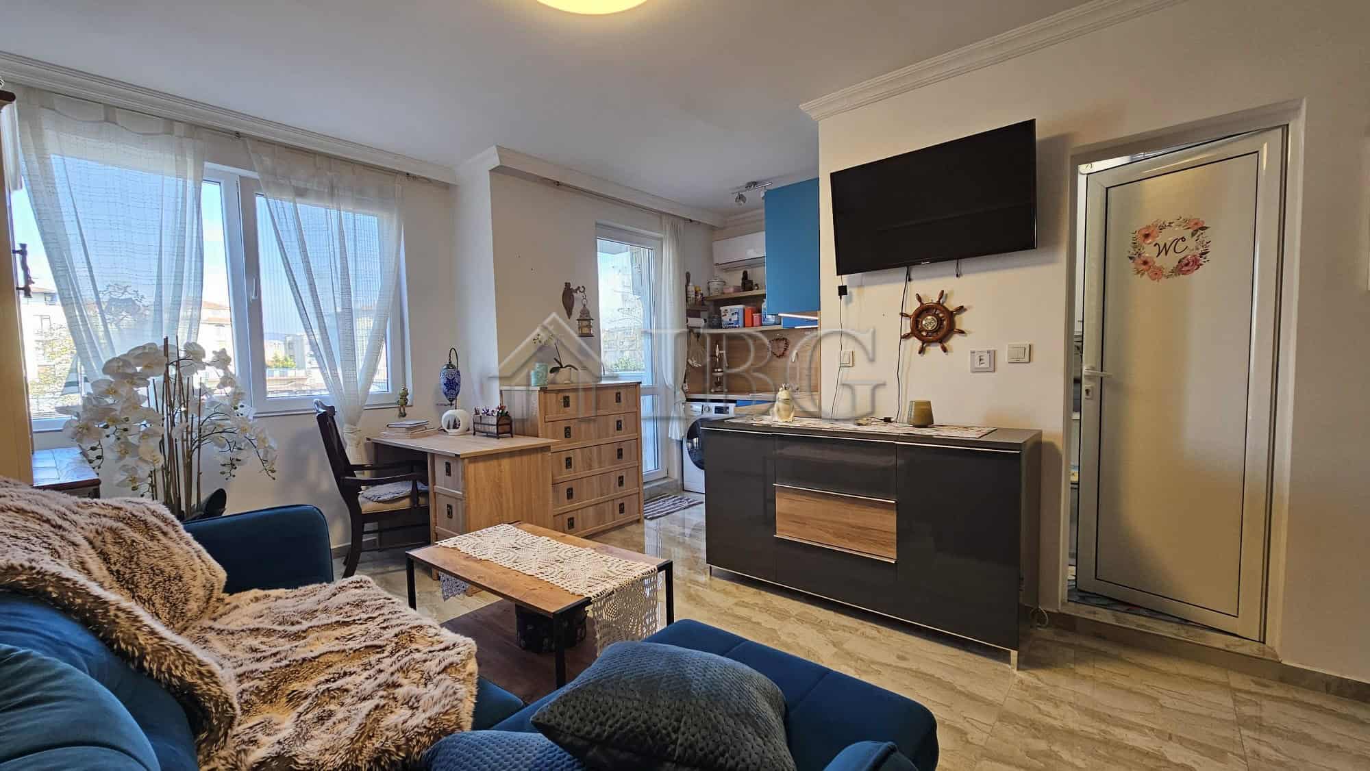 Bright living room with large windows and modern furnishings in Magnolia 6, Sunny Beach.
