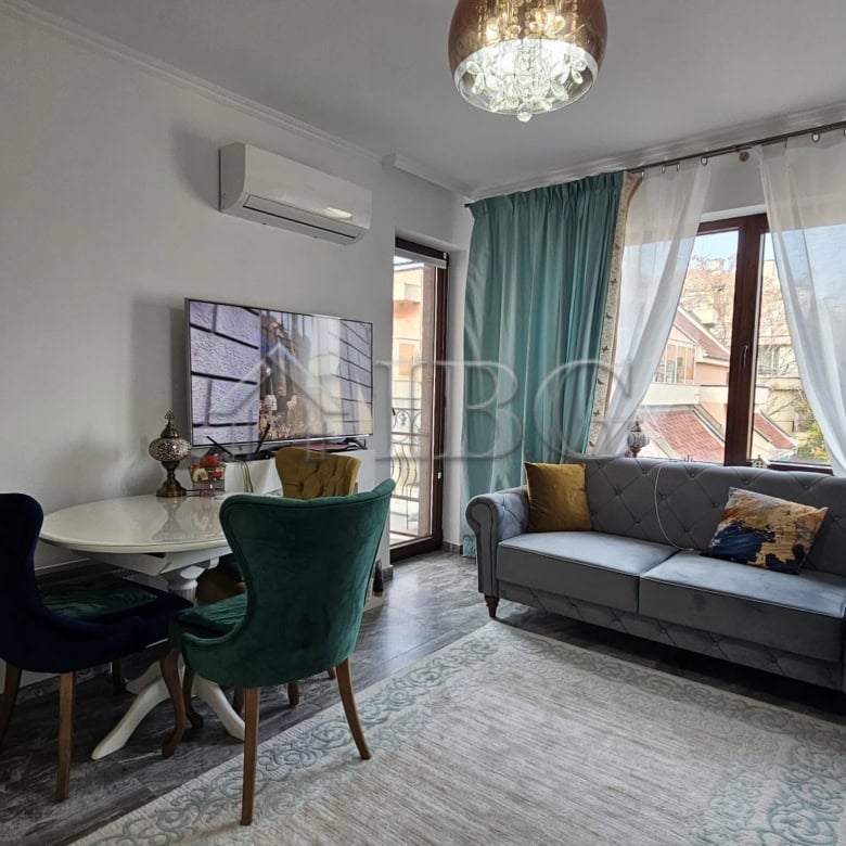 Bright living space with large windows, stylish furniture, and cozy decor.