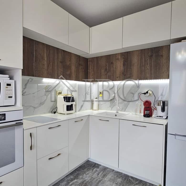 Contemporary kitchen with white cabinets, marble backsplash, and modern appliances in Valencia Garde.