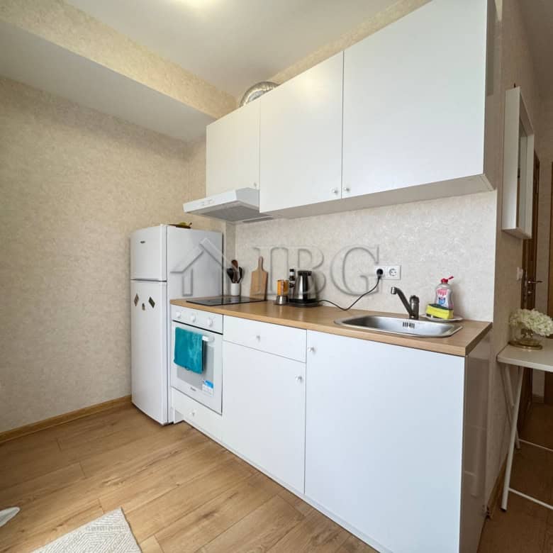 Compact studio kitchen in Aphrodite Park, Sunny Beach with white cabinets and basic appliances.