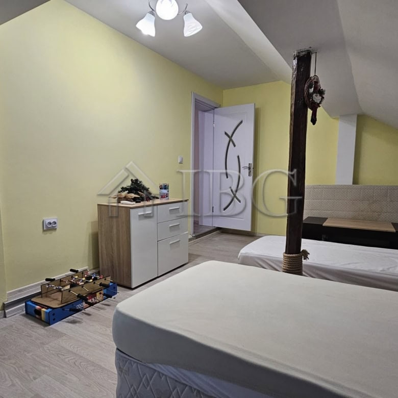 Spacious bedroom with two beds and a small yard area, ideal for family living.