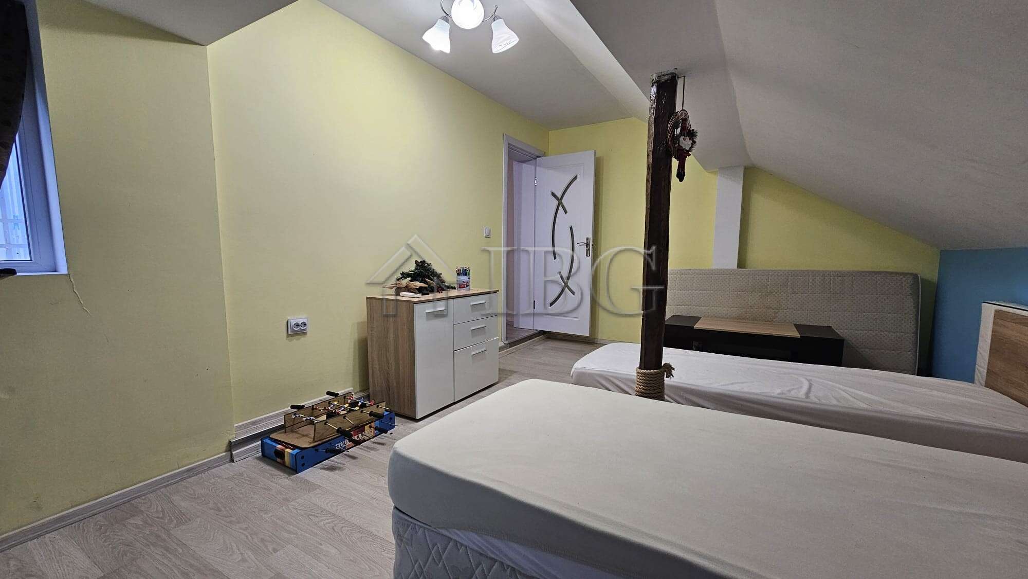 Spacious bedroom with two beds and a small yard area, ideal for family living.