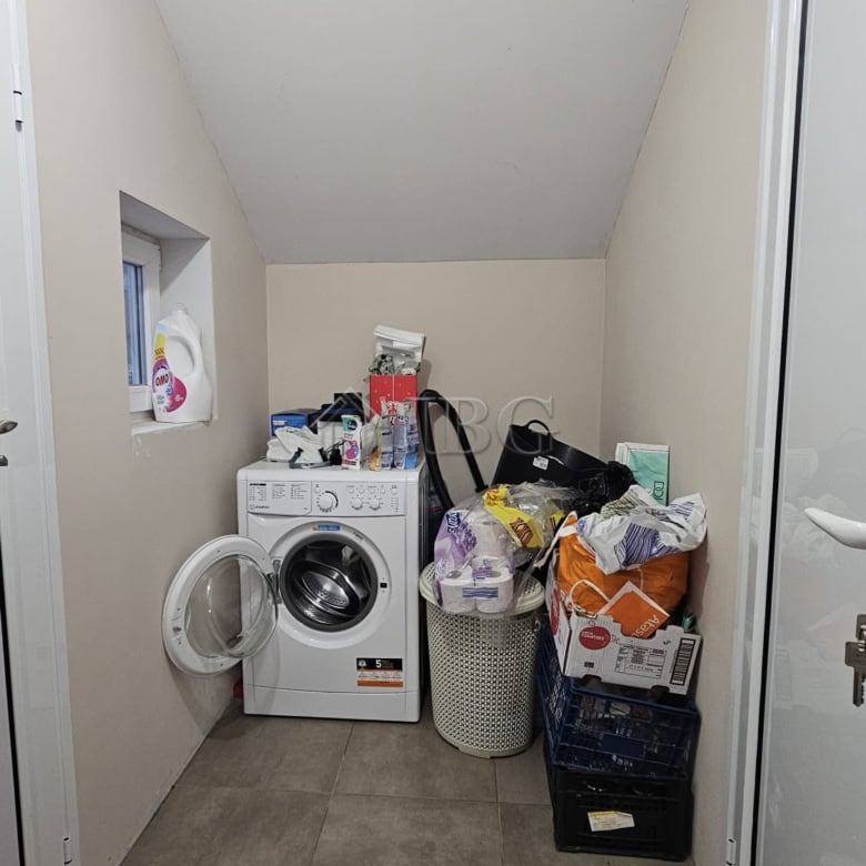 Bright laundry room with washing machine and storage space.