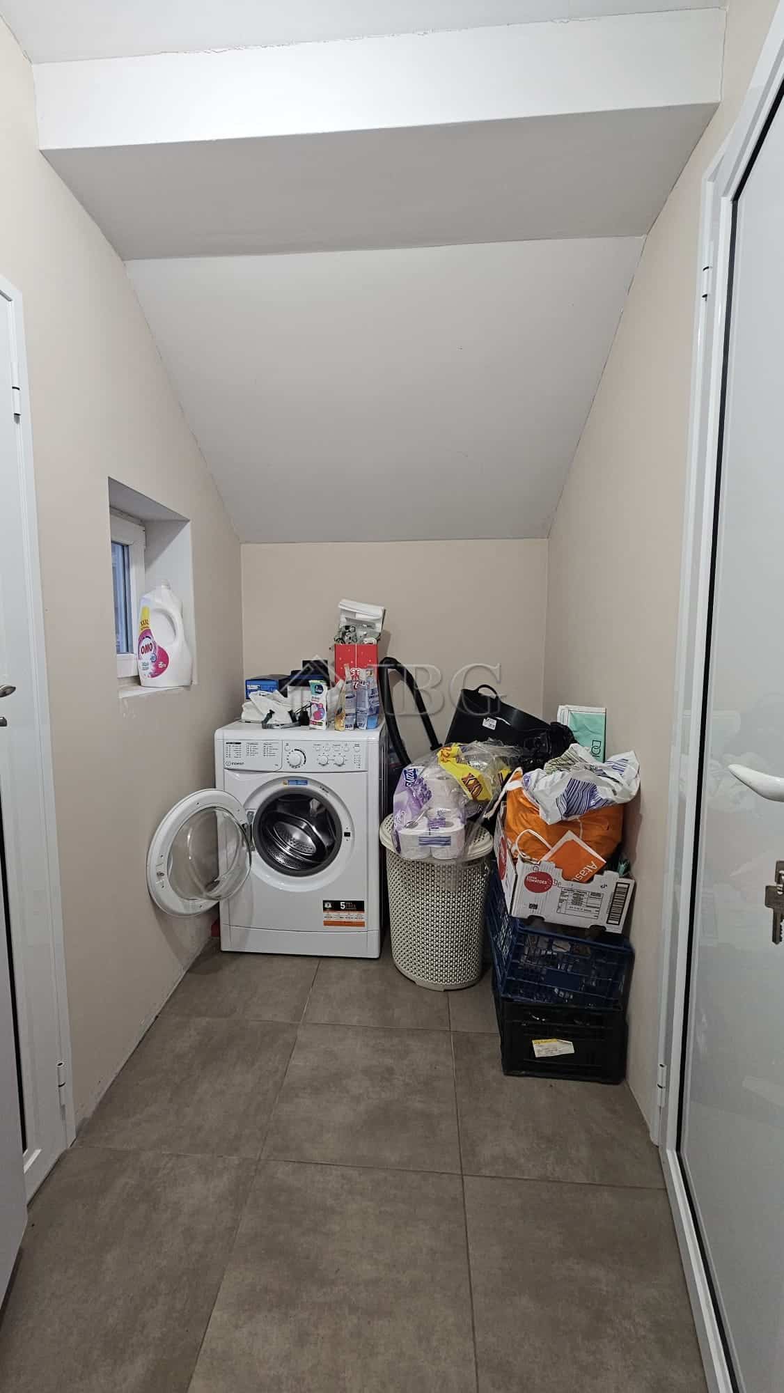 Bright laundry room with washing machine and storage space.
