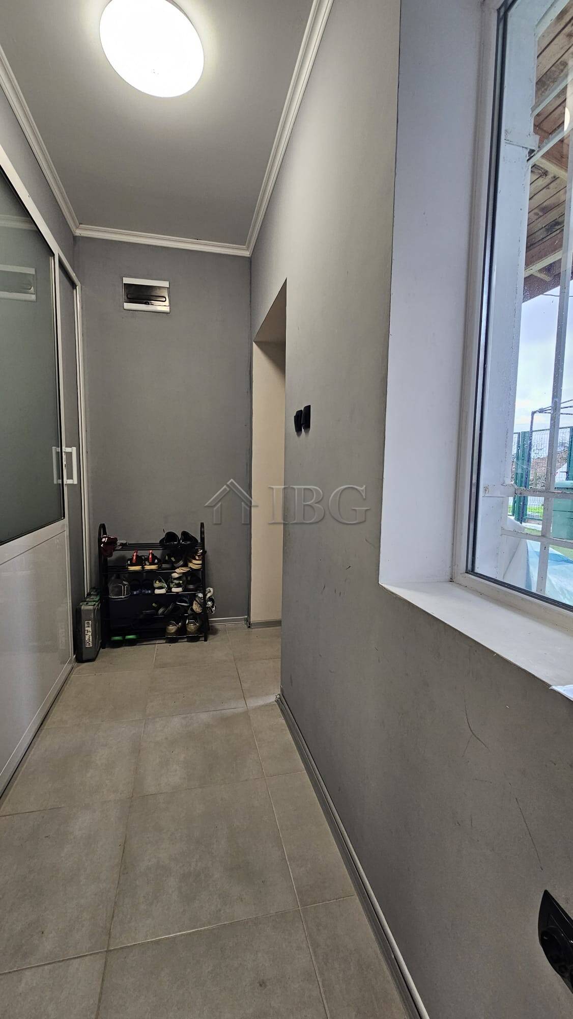 Interior view of a house with a window, exercise equipment, and neutral decor.